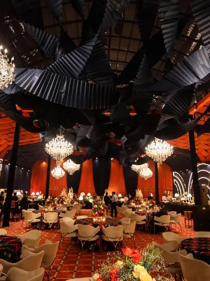 A full view of the Diwali Poker Gala. The decor features a dramatic ceiling with black and orange elements, crystal chandeliers, and modern neon-lit backdrops, creating a sophisticated and high-energy environment.