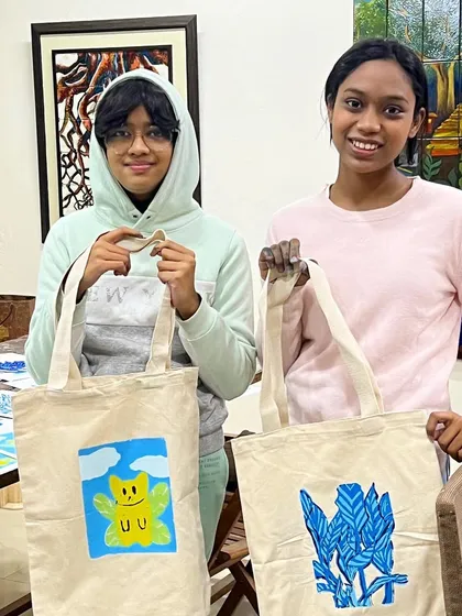 Two proud students showing off their custom-printed tote bags from our serigraphy workshop. They designed and printed these themselves.