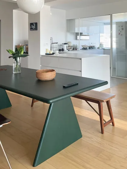 The Conica Dining Table, shown here in a client's home, makes a bold statement with its sculptural dark green base and expansive top. Paired with our Dualtone Bench, this setup demonstrates how our modern designs integrate seamlessly into real living spaces, adding a touch of contemporary yet timeless charm.