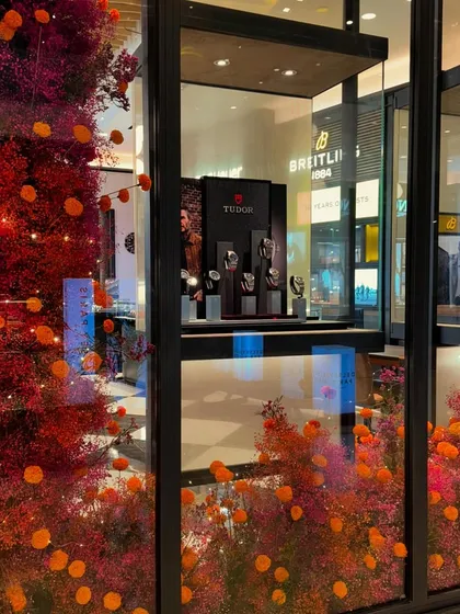 Store windows are a fantastic canvas for joyful floral installations. For this luxury storefront, I used a fiery palette of red and orange dried florals to create a vibrant and eye-catching display that draws you in.