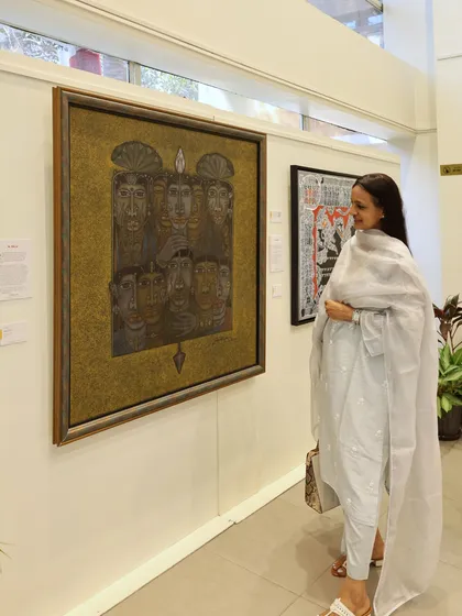 A guest admires a striking metallic artwork, showcasing the diverse mediums and styles present in 'The Masters and The Modern: South Edition.'