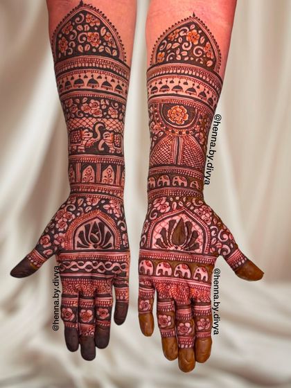A grand, full-coverage design with a royal theme. This piece showcases lotus motifs on the palms, with elephants and architectural details adorning the arms.