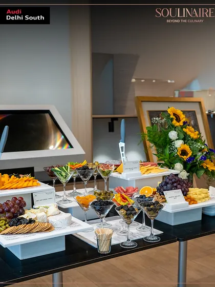 An impressive grazing board featuring a variety of olives, fruits, and cheeses at the Audi art exhibition. Our grazing tables are both a visual and culinary delight.