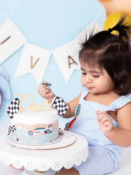 Carefully inspecting the race car decorations on his cake. The details in the themed setups, from the cake toppers to the backdrop, all come together to create a cohesive story.