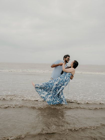 A playful dip and a joyful laugh. This action shot captures the fun and spontaneous side of their relationship, with the ocean as their playground.
