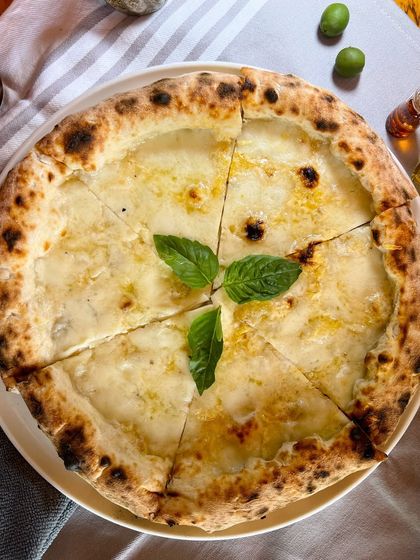 Introducing the Bianca Truffle! A rich, cheesy masterpiece with EVOO, buffalo mozzarella, Grana Padano, Moliterno al Tartufo, and fresh basil.