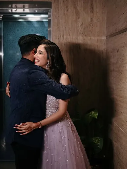 A warm hug just outside the elevator, a candid moment of affection captured before making their grand entrance at the engagement party.