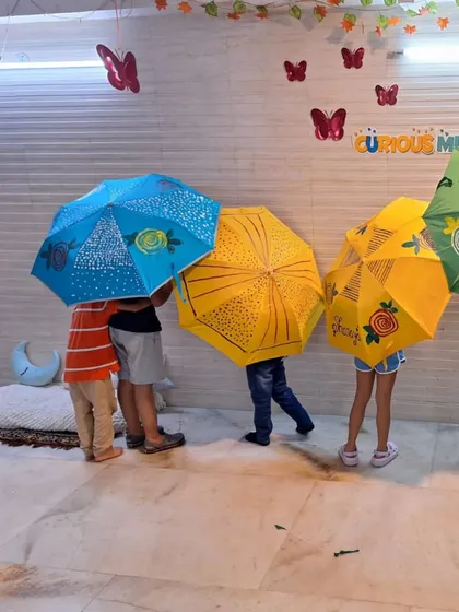 A group of kids playing with their freshly painted umbrellas. The workshop is not just about art, but also about the fun and play that follows.