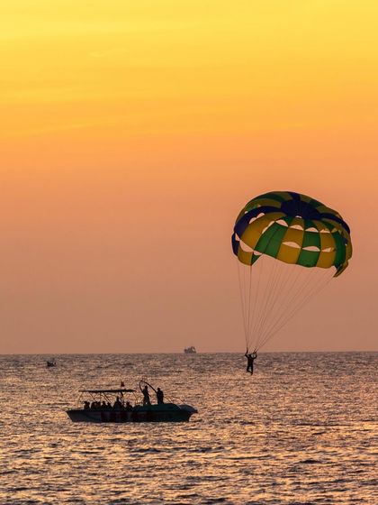 Parasailing against a golden sunset sky. A perfect capture of adventure and beauty combined.
