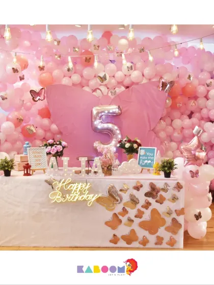 A beautiful butterfly-themed party, where hundreds of pink balloons and delicate butterfly accents create an enchanting and whimsical atmosphere for a fifth birthday.