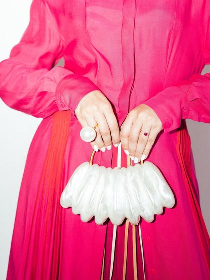 A close-up on the unique, shell-like handbag. Every detail contributes to the overall fashion statement.