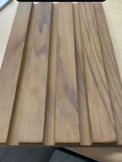 A sample of a solid wood plank with a modern, grooved profile. This is perfect for creating clean, linear patterns on walls or ceilings.