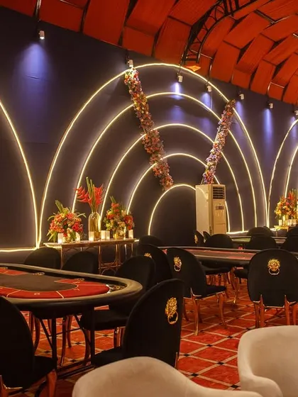 The dedicated poker area, with professional tables set against a backdrop of modern, curved neon lights. The design was meant to feel like an exclusive, high-end casino.