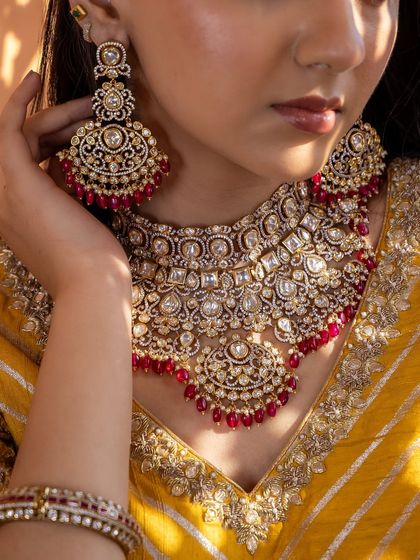 A model wearing the red Kundan bridal set, showing how the choker, earrings, and bangles create a complete and stunning look. This set is designed to be both traditional and eye-catching.