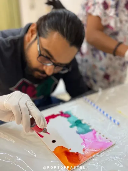 A participant tries alcohol ink art for the first time during a private anniversary workshop.