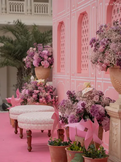 A beautiful corner filled with purple and pink flowers against a pink architectural backdrop, creating a perfect photo opportunity.