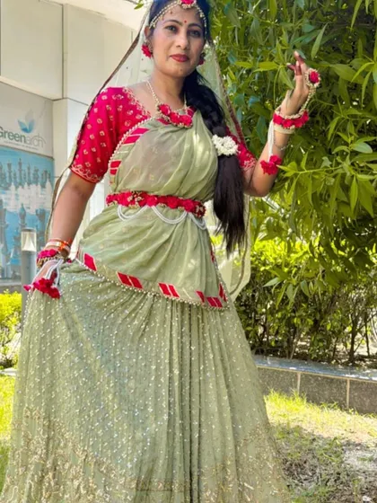 A full-length outdoor shot of the pastel green and pink lehenga, showing how beautifully it flows. The floral belt adds a modern touch.