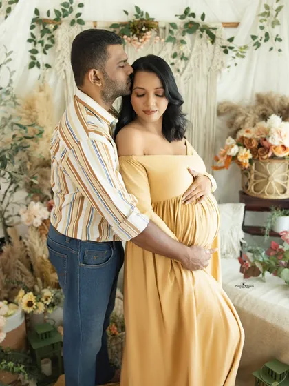 A portrait of love and protection. The husband-to-be wraps his arms around his wife and kisses her forehead, a gesture of tenderness captured in our warm, earthy-toned lifestyle set.