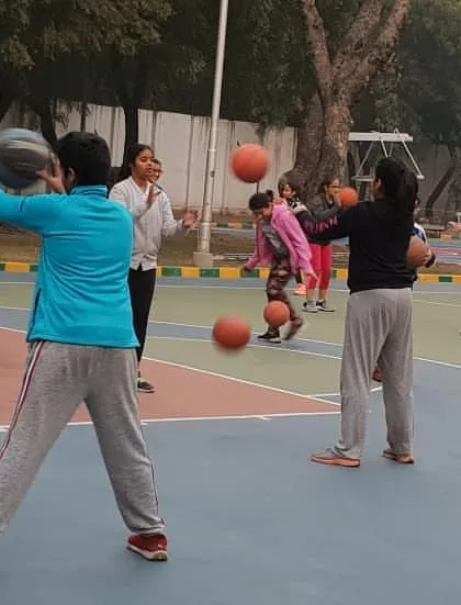 This image captures a two-ball passing drill in progress. These exercises are designed to significantly improve hand-eye coordination, reaction time, and the ability to handle the ball confidently under pressure.