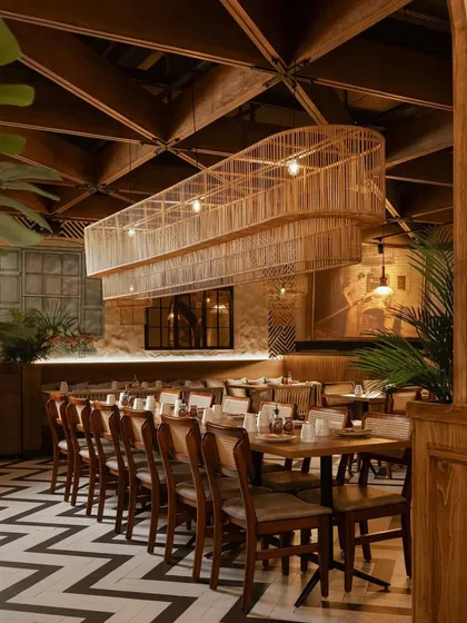 A large, custom-made cane light fixture hangs over the main dining area, creating a dramatic focal point.