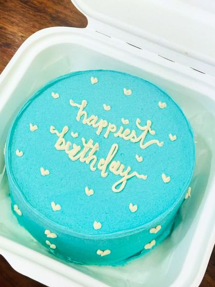 A lovely turquoise bento cake with a simple 'happiest birthday' message. The color is so cheerful and perfect for a celebration.