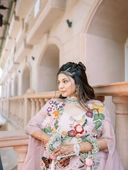 This hairstyle is perfect for a bride who wants a soft, romantic, and slightly bohemian look for her Haldi ceremony.