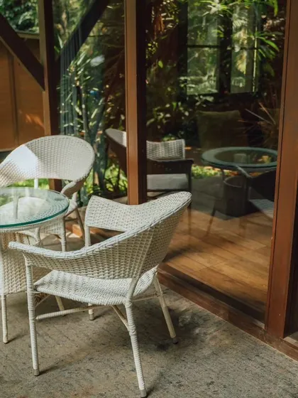A private patio area outside a chalet, the perfect spot to enjoy a morning coffee surrounded by nature.