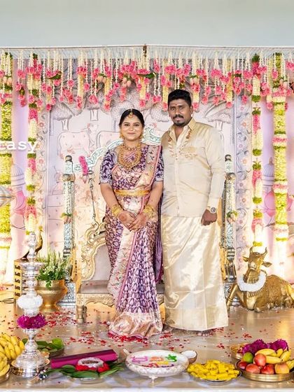 The happy family on stage during their baby's naming ceremony. The grand, traditional decor provides a beautiful and memorable backdrop for their first official family portrait.