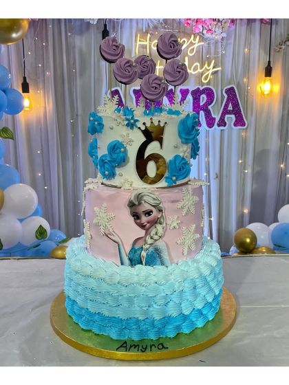 A 3-tier Frozen theme cake made entirely with whipping cream. This Dutch truffle cake features Elsa and beautiful blue and pink frosting details, perfect for a princess party.