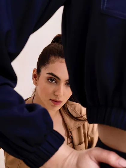 An inventive, framed shot looking through the legs of one model to focus on the other. This creative composition is memorable and adds an artistic flair to the campaign.