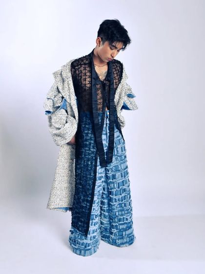 A full-length shot showcasing a layered, avant-garde menswear look. This is perfect for a designer lookbook or a fashion-forward editorial.