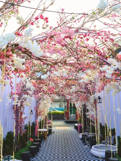 A fairytale entrance of cherry blossoms. This magical walkway is lined with blossoming trees in shades of pink and white, creating a dreamy and romantic path for guests.