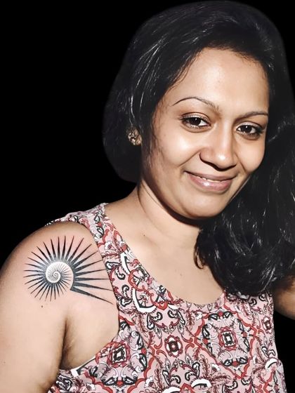 A client proudly showing her geometric sun tattoo.