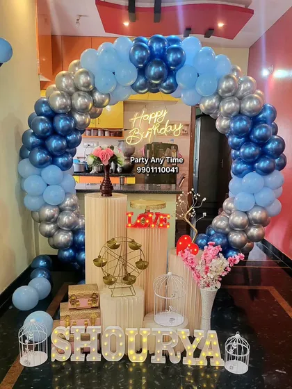 A circular balloon arch in blue and silver chrome for a birthday celebration at home.