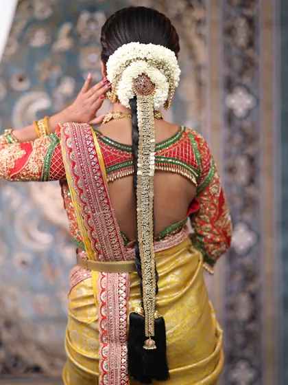 The bridal hairstyle is just as important as the jewellery. This traditional Jadai, or hair ornament, is designed to adorn a long braid, adding a final touch of grace and completing the classic South Indian wedding look.