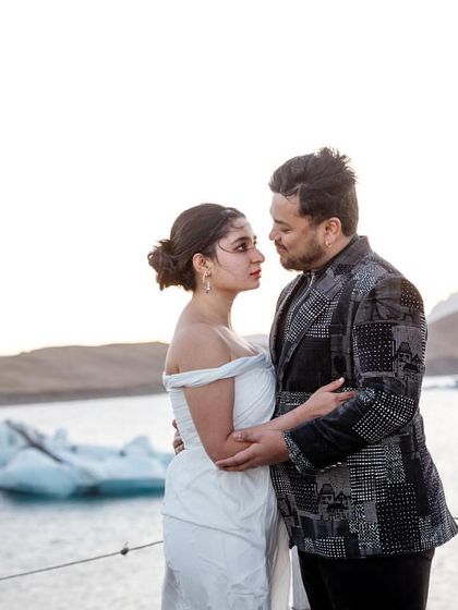 An ethereal, angelic vibe was the goal for this look. We chose a serene white Gaurav Gupta gown that flowed effortlessly against the icy backdrop, with a playful printed blazer for the groom to share the spotlight.