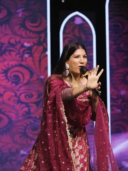 In action during a Sangeet, using hand gestures to engage the crowd and direct the flow of the performances. Dynamic hosting keeps the energy high.