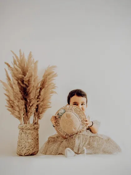 A simple and elegant portrait of a one-year-old. The neutral tones and minimalist props create a timeless image that focuses on her sweet, shy expression.