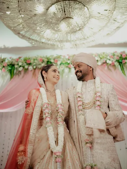 The newly married couple sharing their first look after the rituals, standing under a magnificent chandelier.