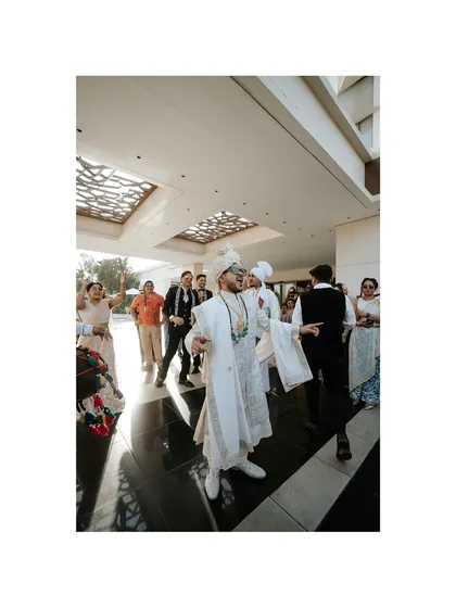 The groom's energetic entrance during the baraat. This photo captures the joy and excitement as he dances his way to the wedding venue.