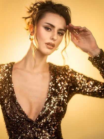 A warm, glowing portrait. I used a backlight to create a beautiful halo effect, with soft front lighting to illuminate the model's face and the sparkling gold sequin dress.
