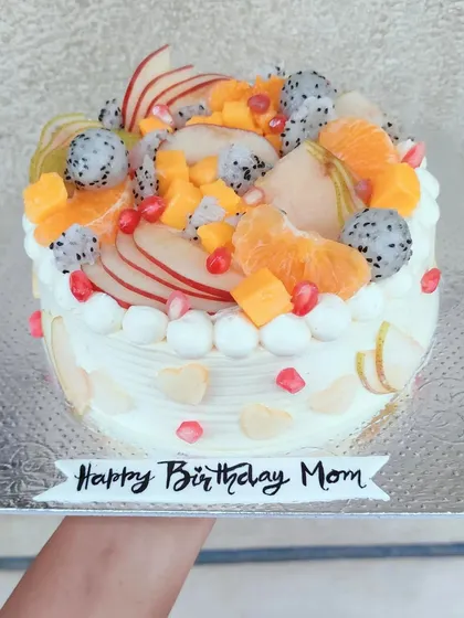 Sometimes, the most beautiful cakes are the simplest. This fresh fruit cake is generously topped with a vibrant assortment of seasonal fruits like dragon fruit, oranges, and pomegranate seeds for a naturally beautiful and delicious treat.