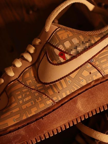A macro shot of the Google Maps sneakers. You can see the fine lines of the map and the subtle variations in the coffee-dyed color, which adds depth and character.