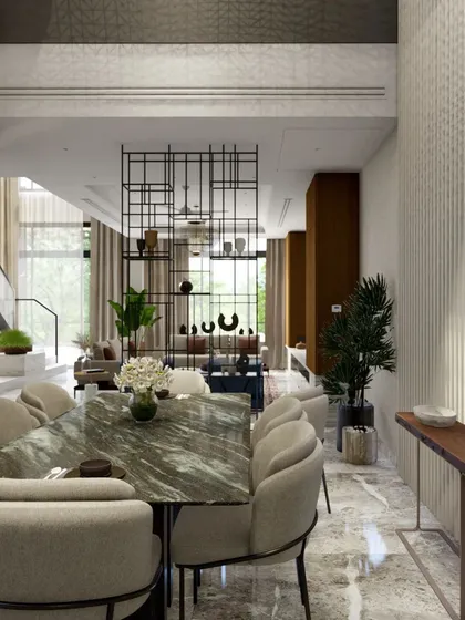 The dining area is situated within a soaring double-height space, with fluted wall paneling adding texture and grandeur. A metal screen provides a subtle division from the living area without blocking light.