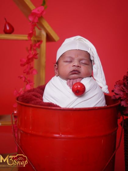 Another angle of the baby in the bucket, showing his tiny hands resting under his chin. It’s all about capturing those adorable details.