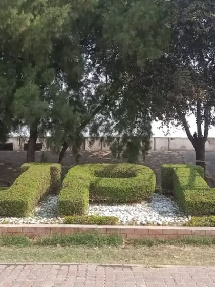 A topiary hedge spelling out "JPL" (Jhajjar Power Limited). This is an example of our custom topiary and branding work for corporate clients.
