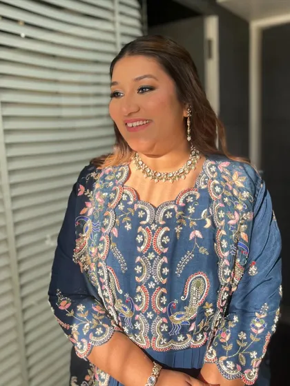Effortless beauty. This look features soft, wavy hair and a classic smokey eye, paired with a beautiful embroidered blue outfit.