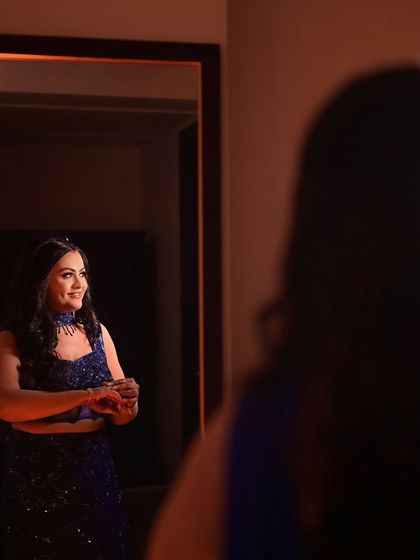 A candid moment of the bride-to-be admiring her final look in the mirror. Her smile shows the confidence that comes from feeling beautiful and ready for her engagement party.