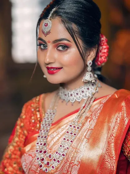 For a dazzling reception or engagement, this American diamond and ruby imitation set is a perfect choice. The intricate design features a statement choker and a layered long necklace, offering a modern yet grand look that is lightweight and comfortable.