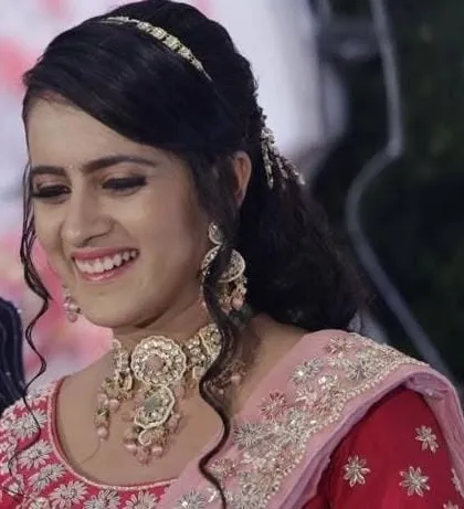 A smiling bride at her reception. The intricate pastel-colored choker with dangling beads adds a playful yet elegant touch.